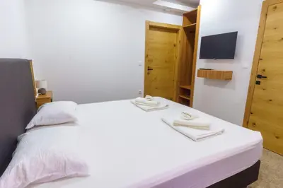 a bedroom with a white bed with towels on it at Motel Aqua Kozarac in Kozarac