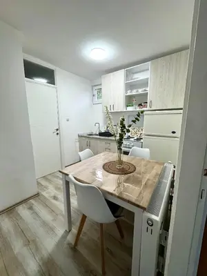 a kitchen with a table with a vase on it at Apartmani Fazinasa