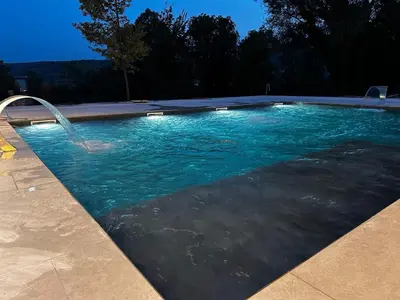 a swimming pool with a water fountain at Apartman Hanna