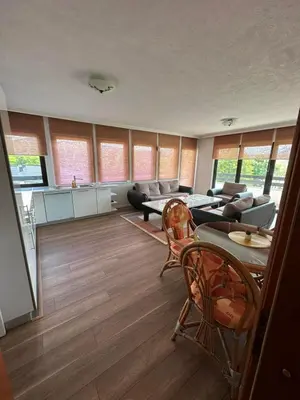 a living room with a couch and a table and chairs at Apartman Hanna