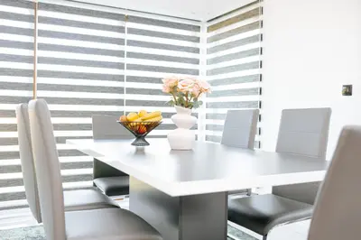 a white dining room table with chairs and a vase of flowers at Velvet House Lohovo in Bihać