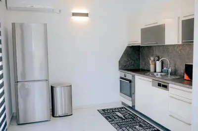 a kitchen with white cabinets and a stainless steel refrigerator at Velvet House Lohovo in Bihać