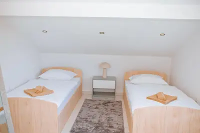 two beds in a room with two hats on them at Velvet House Lohovo in Bihać