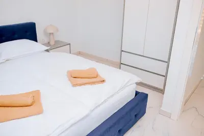 a white bed with two towels sitting on it at Velvet House Lohovo in Bihać