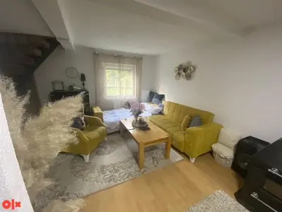 a living room with two yellow couches and a table at Vikendica Sarah in Tuzla