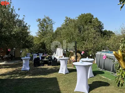 a group of tables and chairs in the grass at Vikendica Sarah in Tuzla