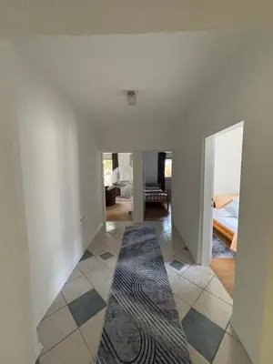 a room with a hallway with a bed and a rug at Horizont Bihać in Bihać
