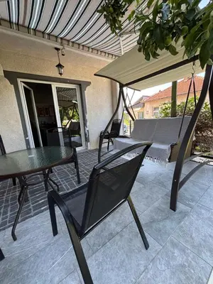 a patio with a hammock and a table and chairs at Horizont Bihać in Bihać