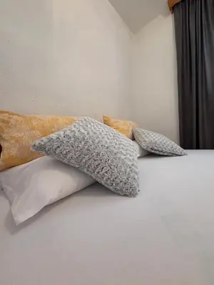 three pillows sitting on top of a bed at Horizont Bihać in Bihać