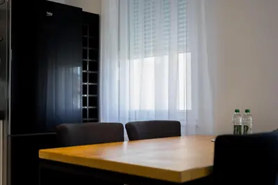 a dining room table with two chairs and a window at Polza in Banja Luka