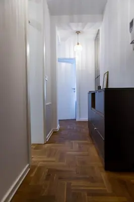 a hallway with a blue door and a wooden floor at Polza in Banja Luka