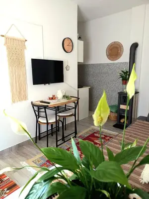 a living room with a table and chairs and a tv at Ćeif HOUSE in Bihać
