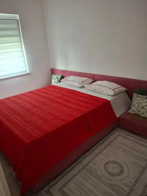 a red bed in a bedroom with a red bedspread at Ćeif HOUSE in Bihać