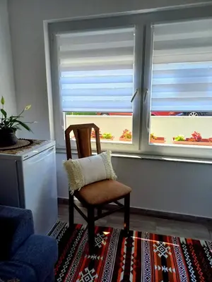 a chair sitting in a room with a window at Ćeif HOUSE in Bihać