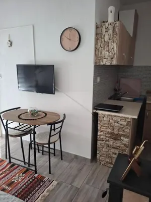 a kitchen with a table and a clock on the wall at Ćeif HOUSE in Bihać