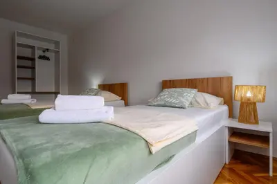 a bedroom with two beds and a lamp at Apartman HAAN in Bihać