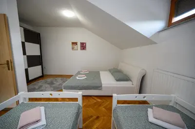 a small room with a bed and two chairs at Apartman HAAN in Bihać