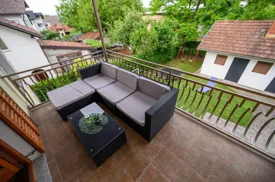 a patio with a couch and a table on a balcony at Apartman HAAN in Bihać