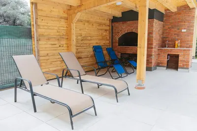 four chairs and a fireplace on a patio at Hafizove ville na Uni in Illidža