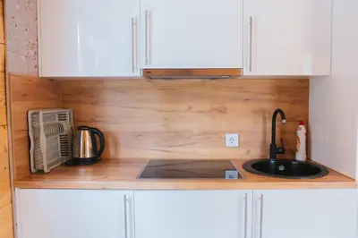 a kitchen counter with a sink and white cabinets at Hafizove ville na Uni in Illidža