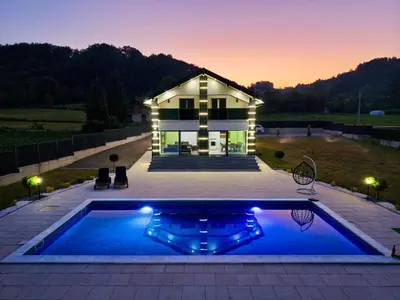 a house with a swimming pool in front of a house at Villa La Casa Del Sol in Srebrenik