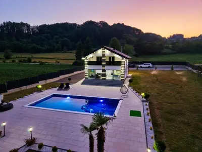 a house with a swimming pool in front of a house at Villa La Casa Del Sol in Srebrenik