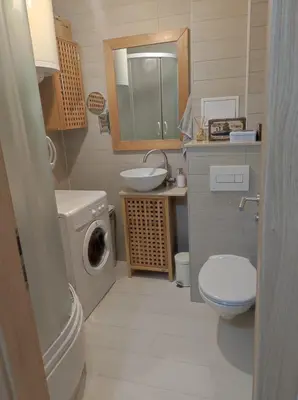 a bathroom with a toilet sink and a washing machine at Apartman Doma in Livno