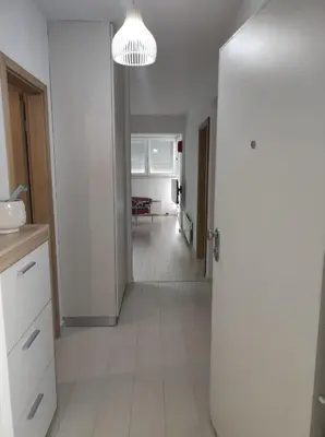 a kitchen with a white floor and a hallway at Apartman Doma in Livno