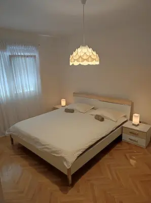 a bedroom with a bed with two lamps on it at Apartman Doma in Livno