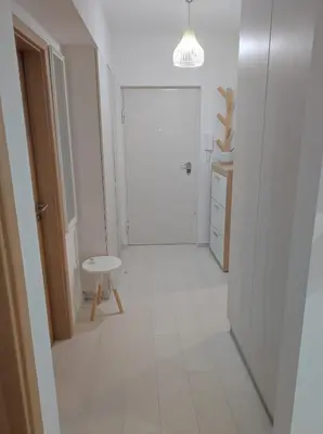 a white hallway with a door and a table at Apartman Doma in Livno