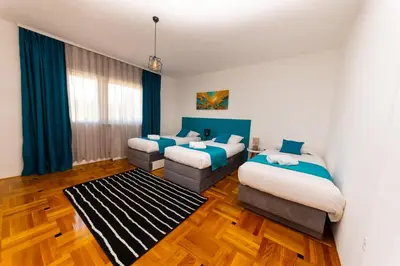 a hotel room with two beds and a couch at Khalilah Apartment 3 in Bihać
