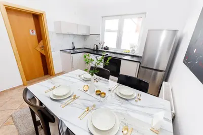 a kitchen with a table with white plates on it at Khalilah Apartment 3 in Bihać