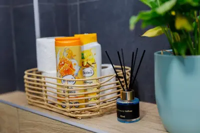 a basket of toiletries on a table next to a vase at Khalilah Apartment 3 in Bihać