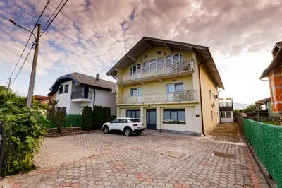 a white car parked in front of a house at Khalilah Apartment 3 in Bihać
