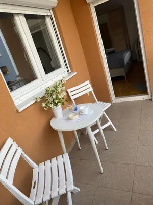 a white table and chairs next to a window at Apartment Boky in Livno