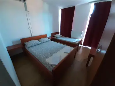 a small bedroom with two beds and a window at Motel Plaza in Bihać