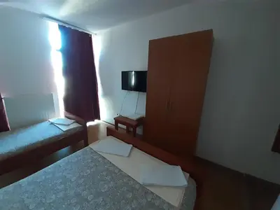 a small room with a bed and a cabinet at Motel Plaza in Bihać