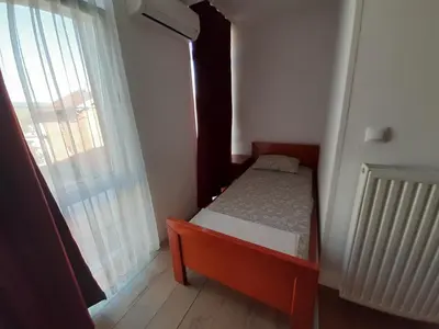 a small bedroom with a bed and a window at Motel Plaza in Bihać