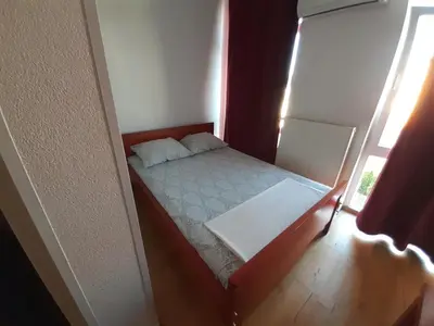 a small bed in a small room with a window at Motel Plaza in Bihać