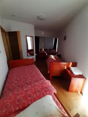 a bedroom with two beds and a desk in it at Motel Plaza in Bihać