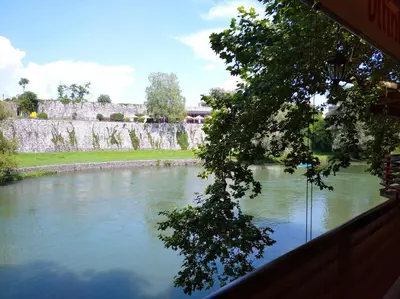 a view of a river with a bridge in the background at Hotel Vila Vrbas in Banja Luka
