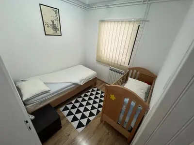 a small bedroom with two beds and a window at Apartman Serdjo