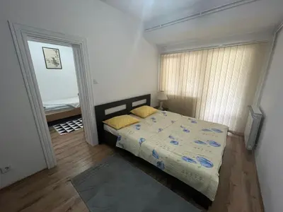 a bedroom with a bed with yellow pillows on it at Apartman Serdjo