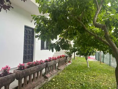 a fence with pink flowers in front of a house at Apartman Serdjo
