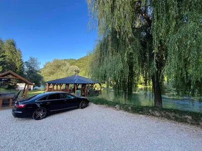a black car parked in front of a gazebo at Apartman Serdjo