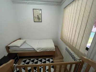 a small bedroom with a bed and a window at Apartman Serdjo