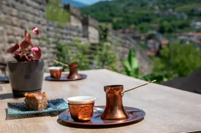 a table with two coffee cups and a cake on it at The Crown Panorama in Jajce