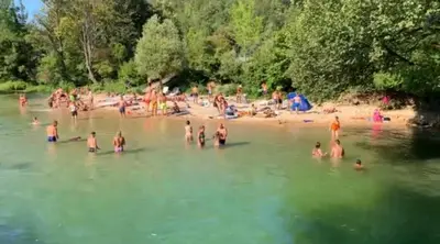 a group of people in the water at a beach at Insula in Otoka