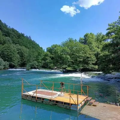 a boat in the middle of a river at Insula in Otoka