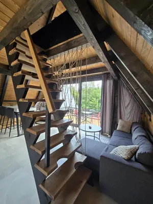 a spiral staircase in a living room with a couch at JAGI Bungalovi Mrkonjic Grad in Mrkonjić Grad